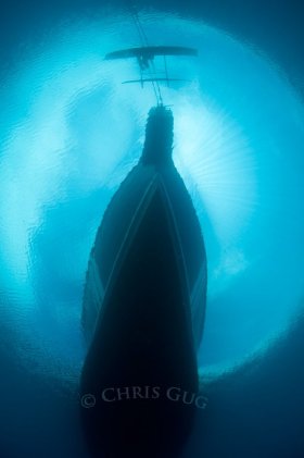 A local PNG canoe plays chicken with a much larger boat. Law of gross tonnage determines the victor. © Chris Gug, All Rights Reserved.