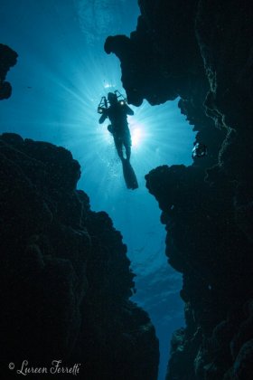 Diver drifting above a canyon photographed in Yap