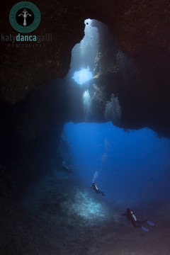 Palau, 2016, Blue Hole site, three divers exit the cavern in perfect symmetry.